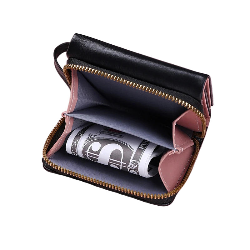 Black leather wallet with gold zipper on a pink background