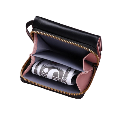 Black leather wallet with gold zipper on a pink background