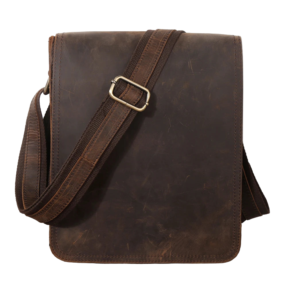 Brown leather bag with a strap on a wooden surface