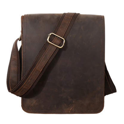 Brown leather bag with a strap on a wooden surface