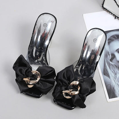 Black sandals with gold buckles and black ribbons