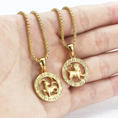 Two gold necklaces with zodiac pendants on a hand
