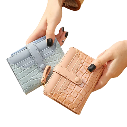 Two_wallets_one_light_blue_and_one_beige_with_crocodile_texture_held_by_a_hand
