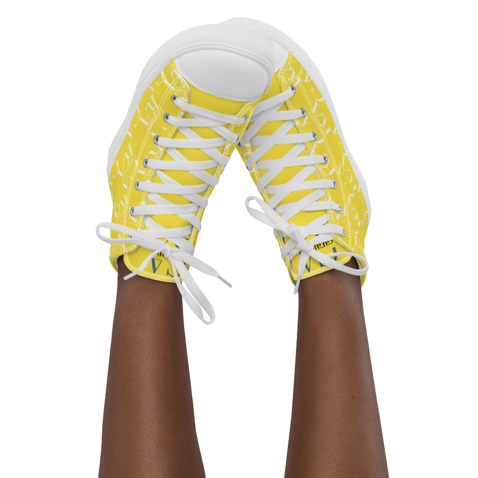 Yellow sneakers with white laces worn by a person on a white background
